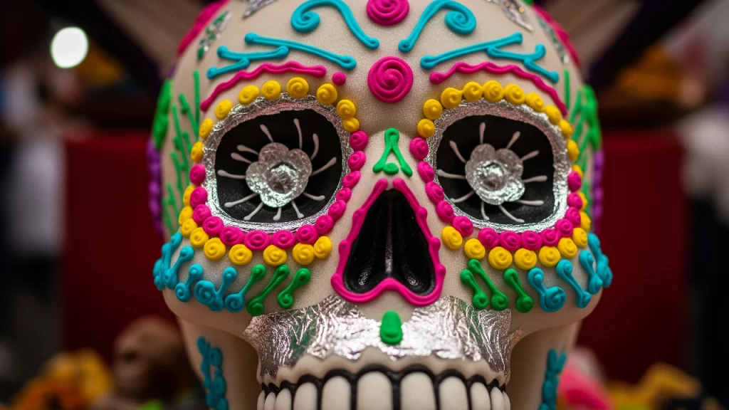 Fotografía macro de una calavera de alfeñique de la tradicional feria de Toluca, destacando los finos detalles y colores vibrantes del dulce artesanal.